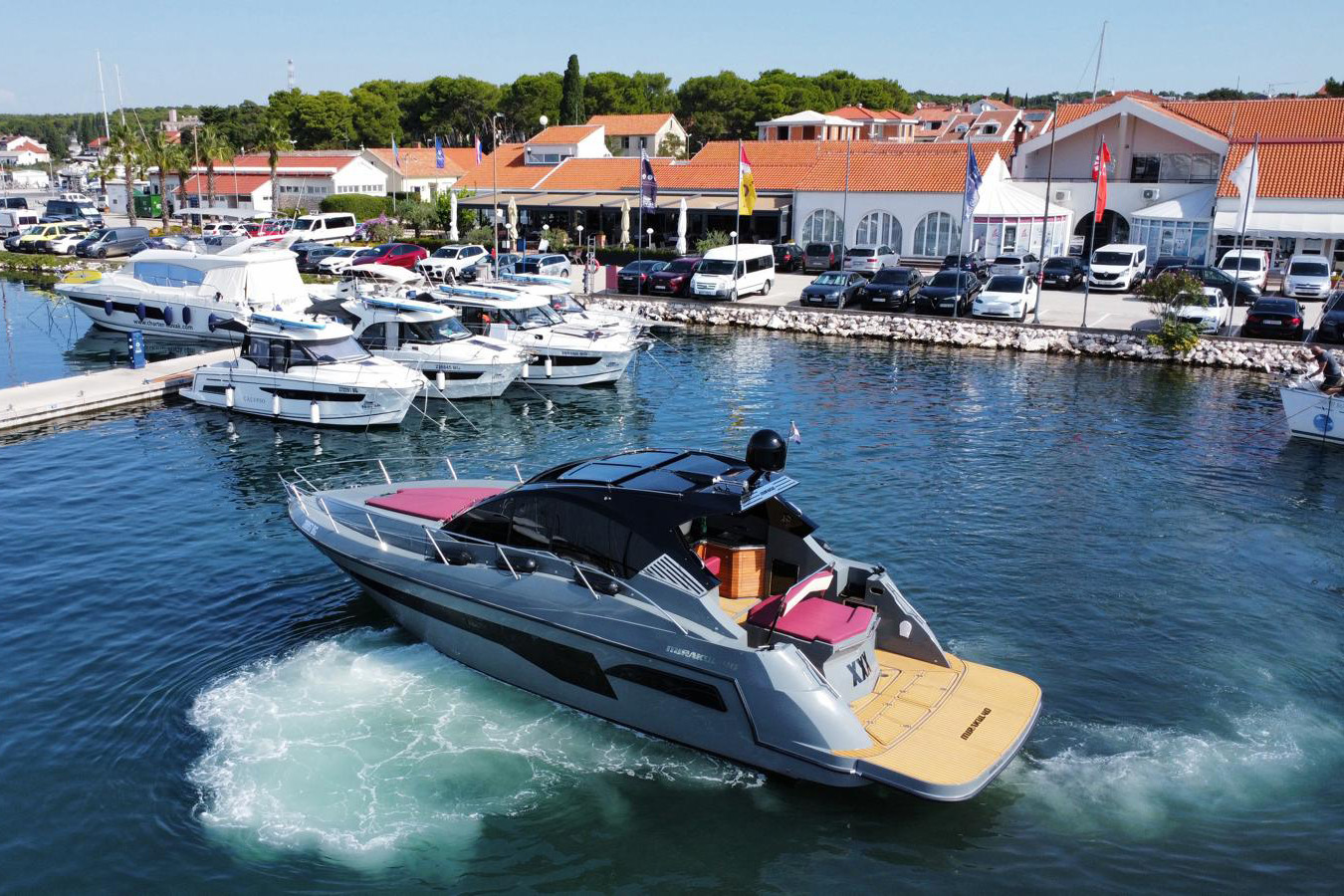 Mirakul 40, luksuzna jahta okreće na mjestu; sivo-crna kombinacija, bordo jastuci i prostrana krmena platforma uz moderne gatove