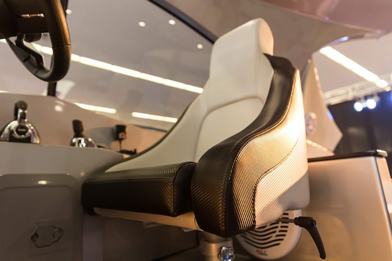 Sportsko kapetansko sjedalo na Mirakulu 40 s bijelim presvlakama i crnim bočnim umetcima s izgledom karbona, postavljeno na podesivom stalku uz kormilo