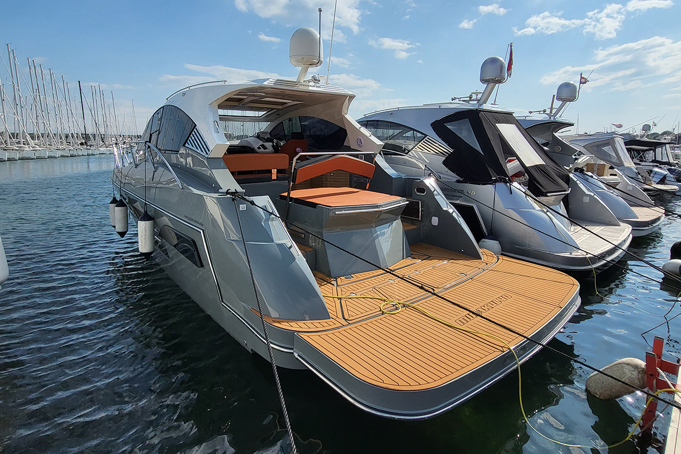 Krmeni dio Mirakul 40, luksuzna jahta na vezu; velika tikova platforma, narančasti jastuci na sunčalištu i hard-top s navigacijskom kupolom