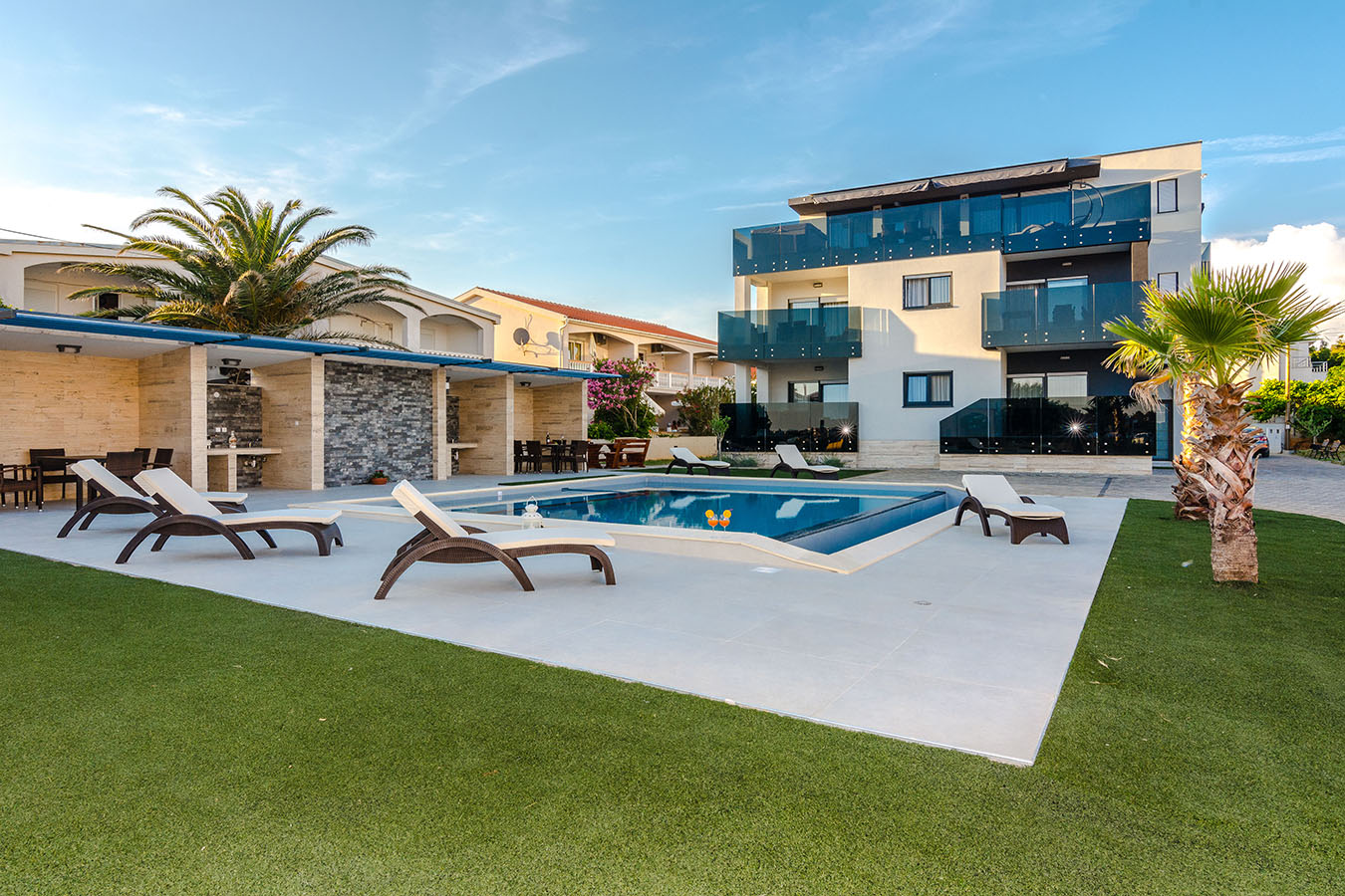 Vanjski bazen s ležaljkama ispred Resorta Mirakul na otoku Vir – moderan smještaj za obitelji i parove