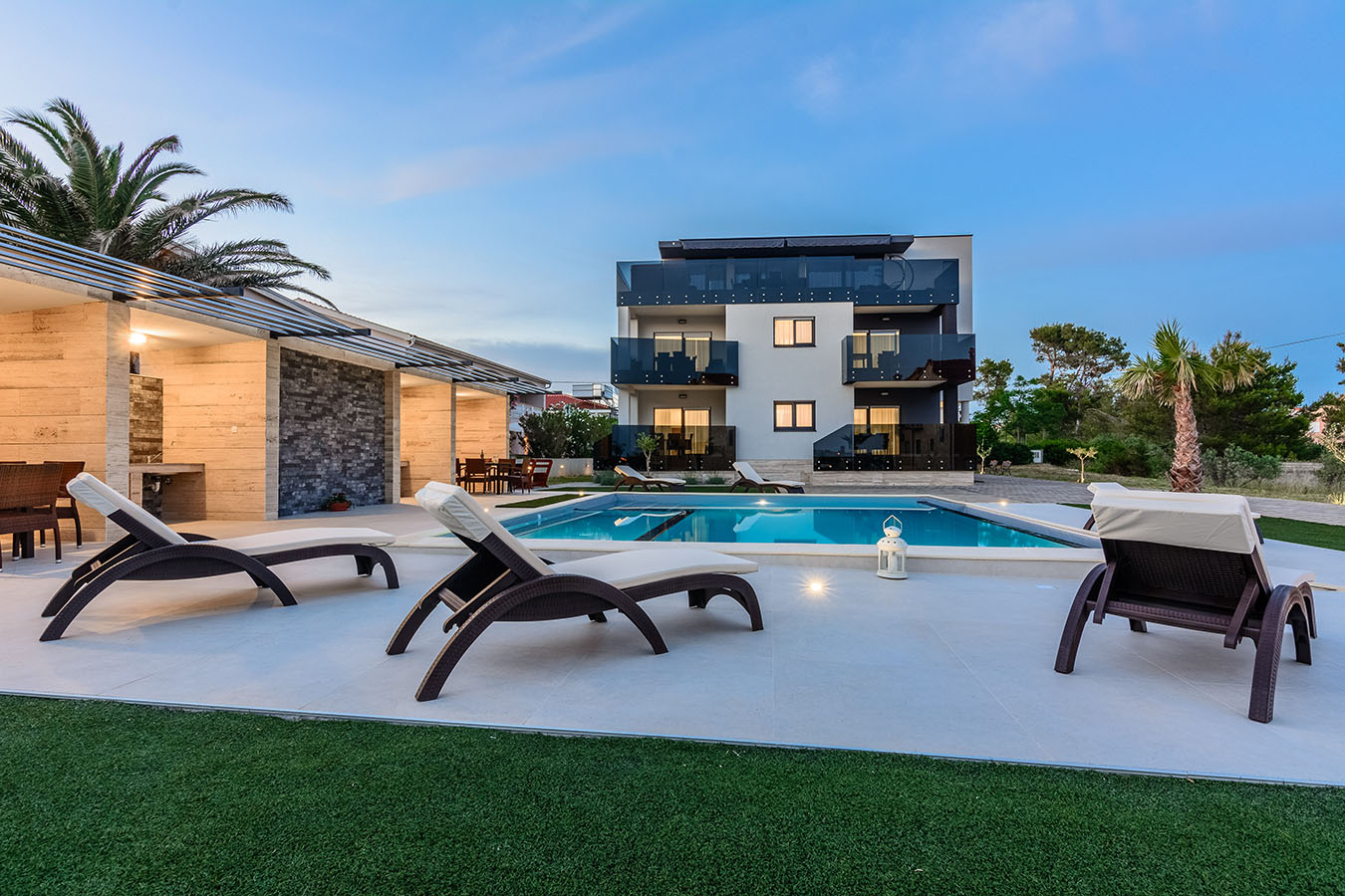 Večernja atmosfera uz osvijetljeni bazen i ležaljke – mirno okruženje za odmor na otoku Viru