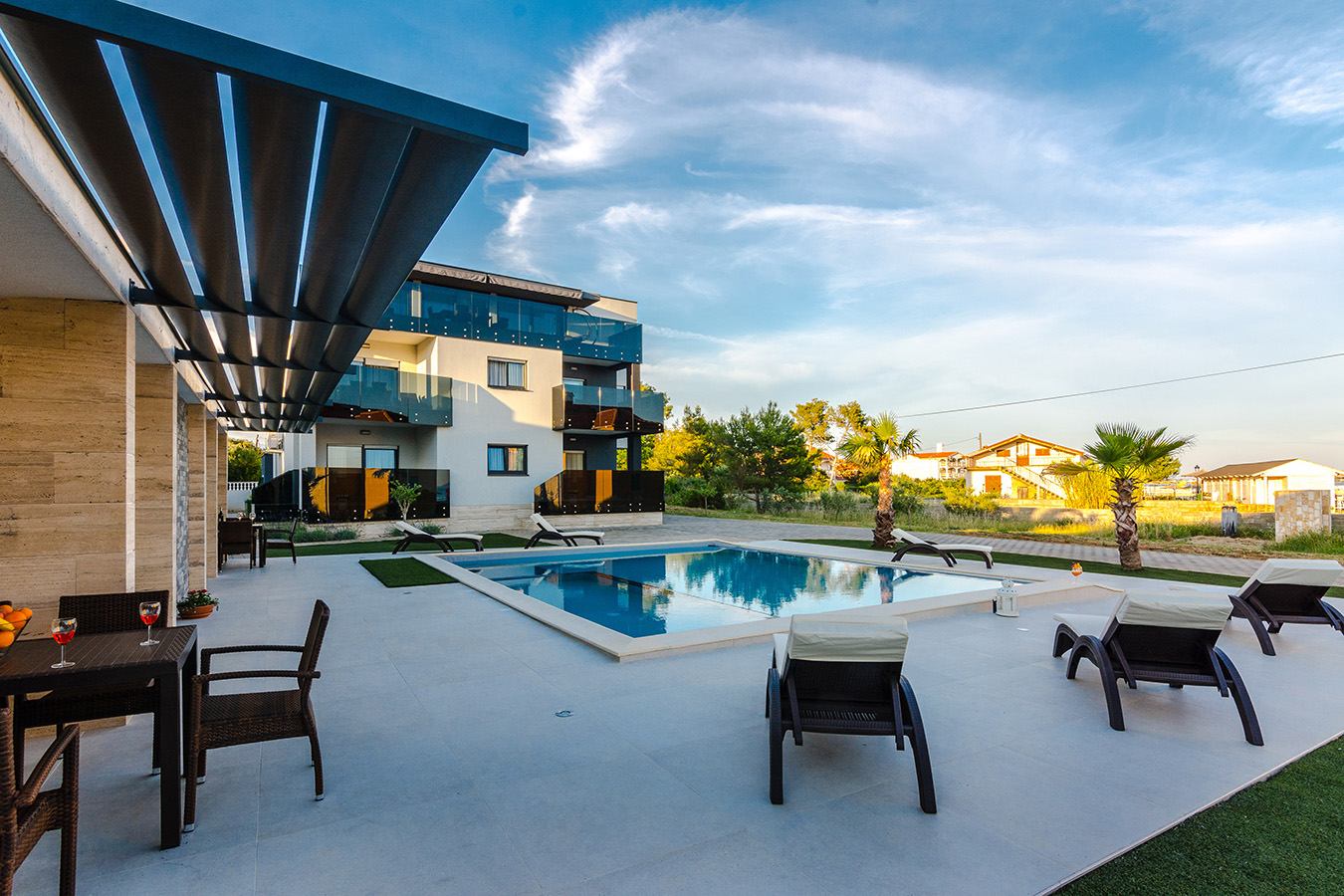 Prostrana terasa uz bazen, moderne ležaljke i stakleni balkoni – luksuzni apartmani s bazenom, otok Vir