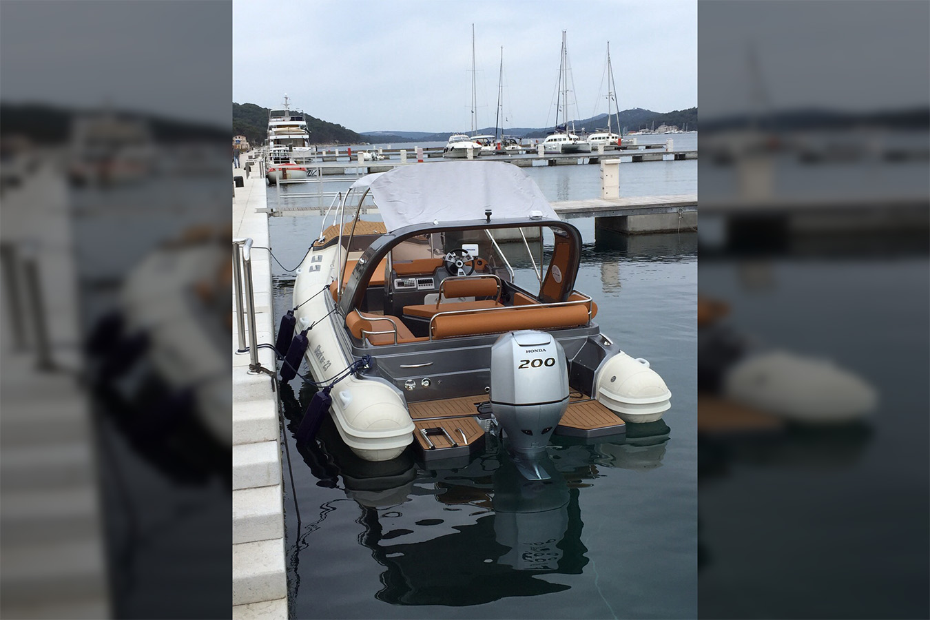 Pogled s krme na 'luksuzni gumenjak' Shark 23 s vanbrodskim motorom Honda 200, privezan u marini