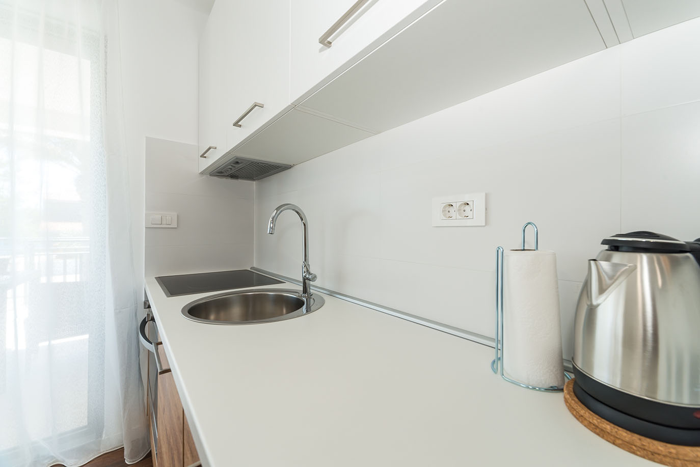 Svijetla i moderna kuhinja s bijelim ormarićima, inox sudoperom, električnom pločom i kuhalom, idealna za boravak u apartmanima Vir