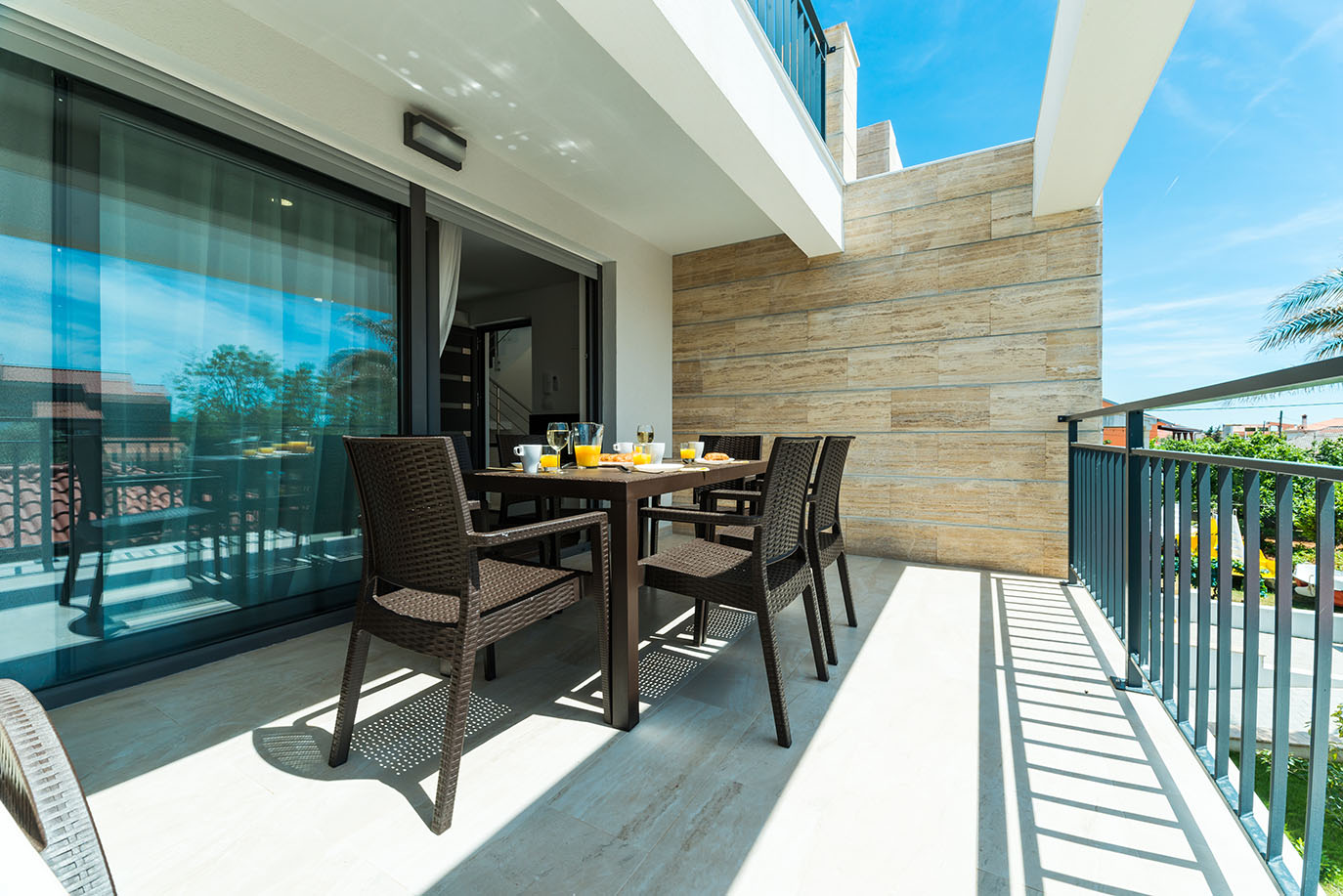 Moderni balkon s vanjskim stolom za blagovanje pripremljenim za doručak, idealan za goste apartmana Vir